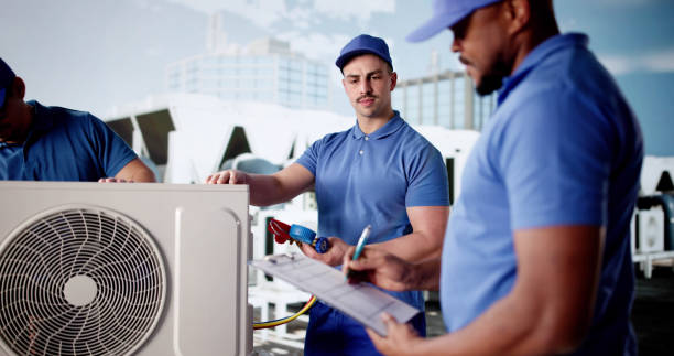 diverse group of workers install air conditioner in commercial building. diverse group of workers install air conditioner in commercial building.