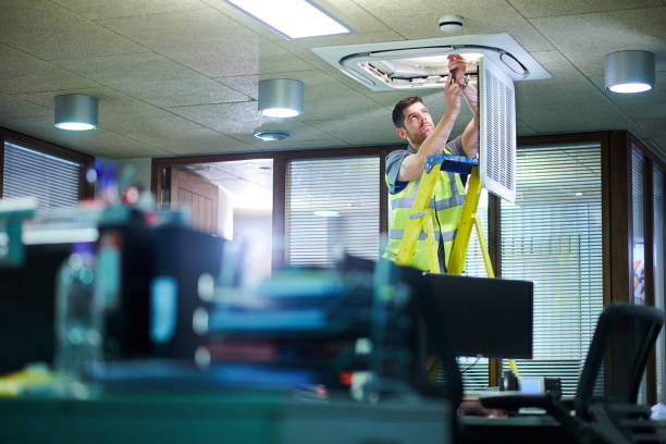 air con maintenance engineer in empty office floor air con maintenance engineer in empty office floor